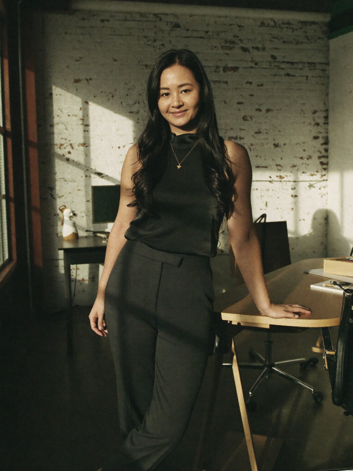 Jenn Yang, director of DotVA, leaning against a desk in a Melbourne studio