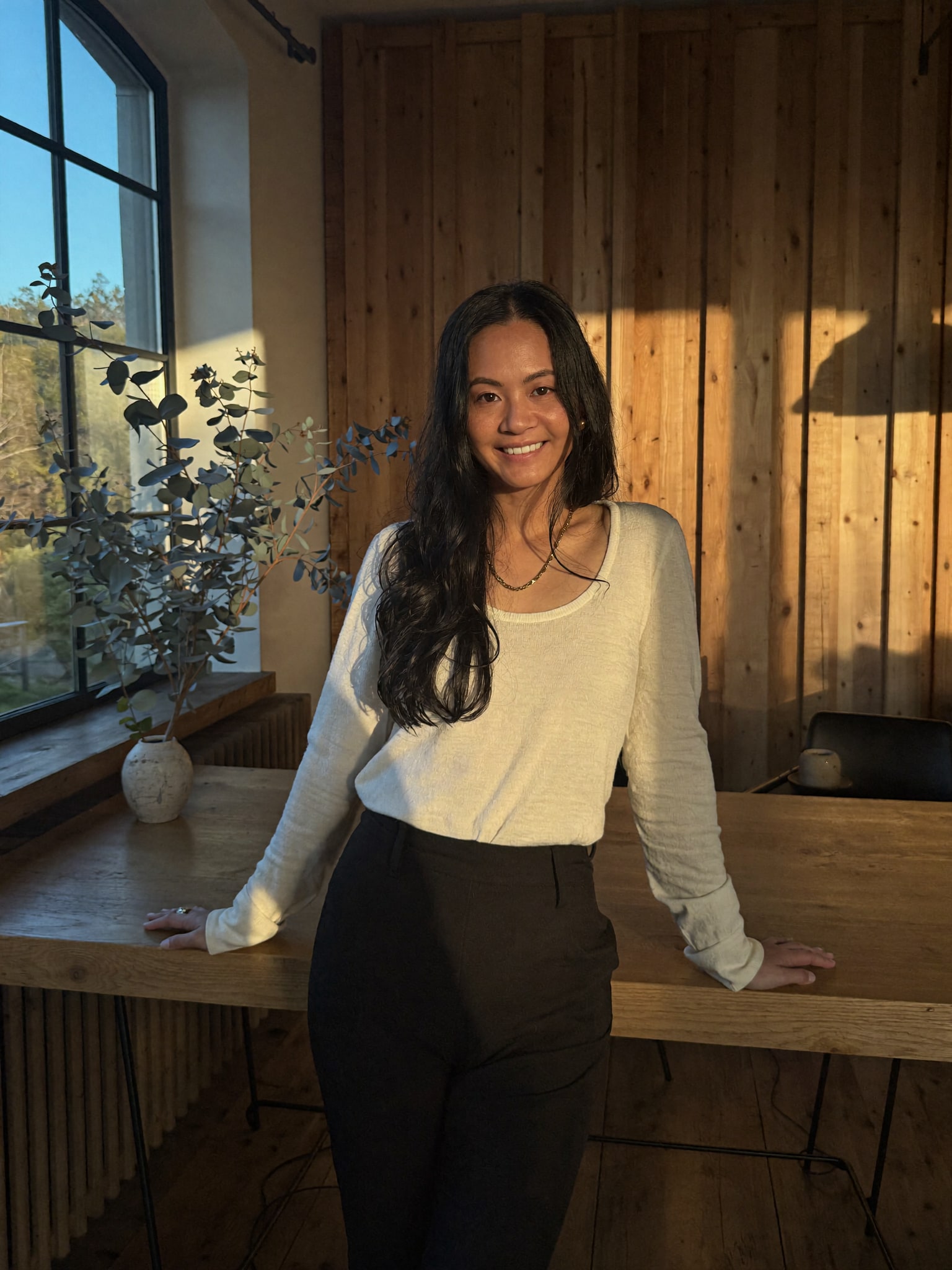 Jenn Yang, director of DotVA, at her timber workspace in warm afternoon light